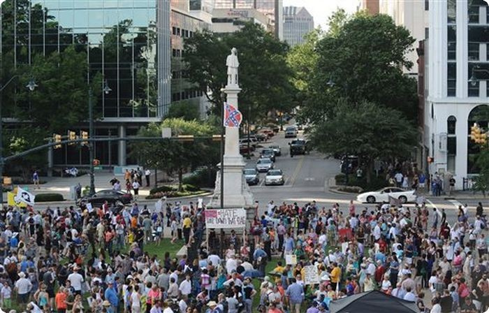 Protesters stand around a flying Confederate flag during a rally to take down the flag at the South Carolina Statehouse, Saturday, June 20, 2015, in Columbia, S.C. Rep. Doug Brannon, R-Landrum, said it's past time for the Confederate flag to be removed from South Carolina's Statehouse grounds after nine people were killed at the Emanuel AME Church shooting. (AP Photo/Rainier Ehrhardt) 