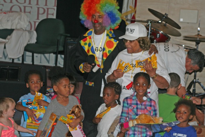 Brian Ferguson, as ‘Christian the Clown,’ distributes toys to children.