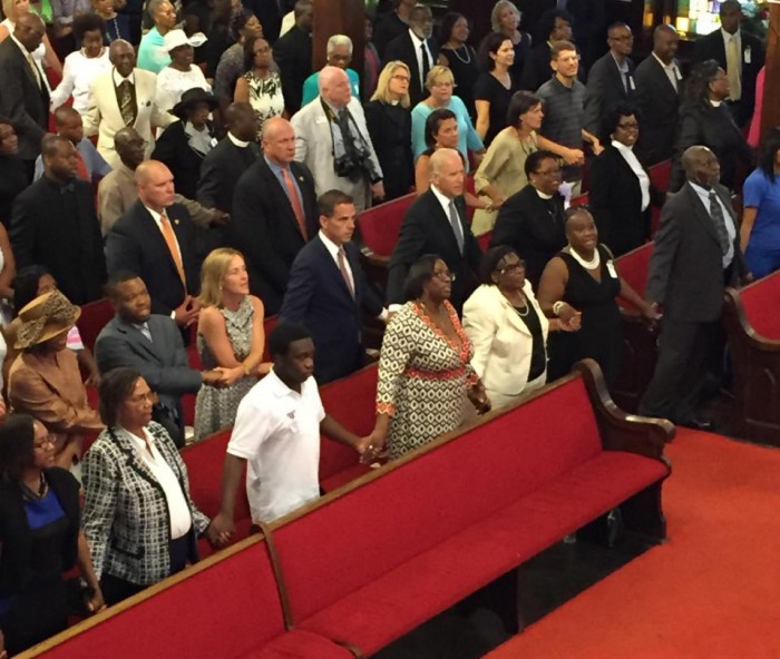 U.S. Vice President Joe Biden, center, with son and daughter-in-law Hunter and Kathleen Biden, to his right, sing We Shall Overcome while joining hands with Emanuel AME Church members Sunday, June 28, 2015 in Charleston, S.C. Biden delivered a short speech and said he was there to stand in solidarity with the church and families of the nine people who were killed June 17.  (Melissa Boughton/The Post and Courier via AP)