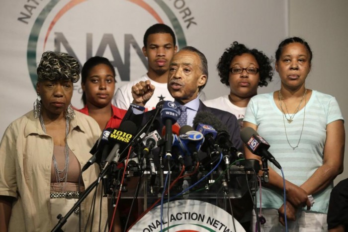 The Rev. Al Sharpton, center, is joined by Eric Garner's mother Gwen Carr, left, daughter Erica Garner, second from left, son Eric Garner, third from left, daughter Emerald Snipes, second from right, and wife Esaw Snipes, as he speaks during a news conference, Tuesday, July 14, 2015, in New York. The family of Garner, a black man who died after being placed in a white police officer's chokehold, discussed the $5.9 million settlement it reached with the city days before the anniversary of his death. (AP Photo/Mary Altaffer)