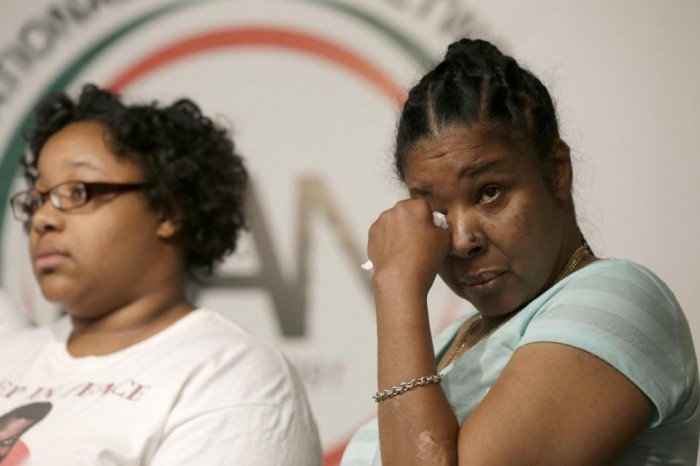 Eric Garner's wife Esaw Snipes, right, wipes a tear from her eye as she stands with daughter Emerald Snipes during a news conference, Tuesday, July 14, 2015, in New York. The family of Garner, a black man who died after being placed in a white police officer's chokehold, discussed the $5.9 million settlement it reached with the city days before the anniversary of his death. (AP Photo/Mary Altaffer)