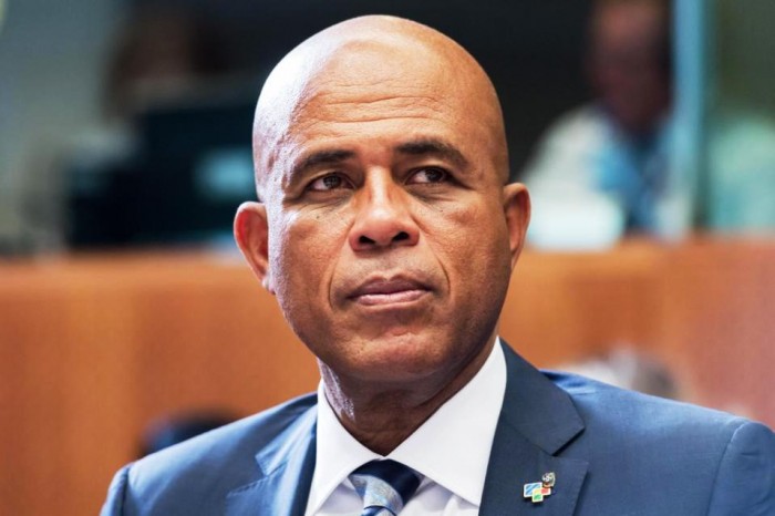 In this June 10, 2015 file photo, Haiti's President Michel Joseph Martelly waits for the start of a round table meeting at the EU-CELAC summit in Brussels. Hostile comments made by Martelly to a woman at a campaign rally in Haiti have prompted a party in his coalition to remove three officials from his government. Martelly was at a rally in late July 2015 when a woman complained that his government failed to bring electricity to her community. Haitian media reported that he told her in Haitian Creole to “go get a man and go in the bushes” to have sex. (AP Photo/Geert Vanden Wijngaert, File)