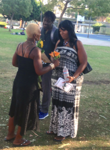 Traci Freeman hands flowers to guests during Homeless Memorial Service. (Charlene Muhammad photo)