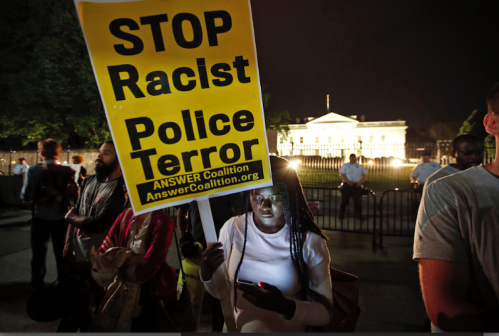 Protestors gather outside Clarence M. Mitchell Jr. Courthouse, Monday, Nov. 30, 2015, in Baltimore, after the arrival of William Porter, one of six Baltimore city police officers charged in connection to the death of Freddie Gray. Porter, whose trial jury selection began Monday, faces charges of manslaughter, assault, reckless endangerment and misconduct in office. (AP Photo/Patrick Semansky)