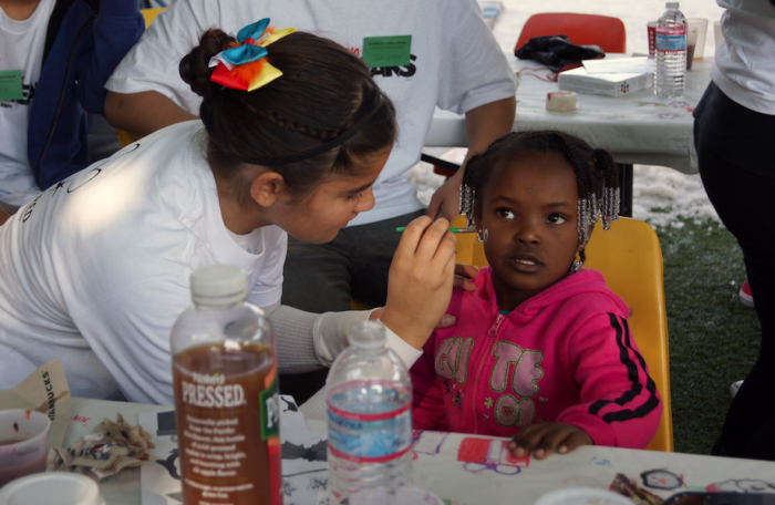 A young resident enjoys face painting at A Place Called Home’s Christmas event in South L.A. December 19, 2015. (photo: Valda Whyte, A Place Called Home)