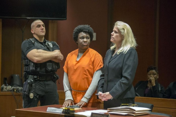 With her mother Juana Sully seated behind her, Hyphernkemberly Dorvilier, stands between a sheriff's deputy and her defense attorney Karen Thek as she listens to the charges against her. (Ed Hille/The Philadelphia Inquirer via AP)