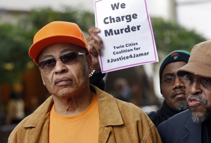 James Clark, right, the father of Jamar Clark, listens during a news conference Thursday, March 17, 2016, in Minneapolis where protesters called for prosecution of two Minneapolis police officers in the shooting death of Jamar Clark last November. County Attorney Mike Freeman on Wednesday said he will not be using a grand jury to decide whether to prosecute the officers. Clark says he wants to see the officers prosecuted for his son's death. (AP Photo/Jim Mone)