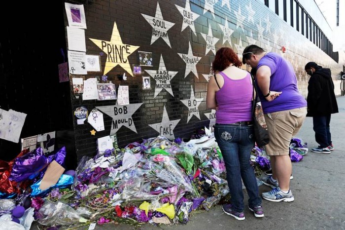 A star honoring Prince, now painted gold, stands out on the wall Thursday, May 5, 2016 as fans gathered at the memorial for the singer at First Avenue in Minneapolis where he often performed. The pop rock singer died on April 21 at the age of 57. (AP Photo/Jim Mone)