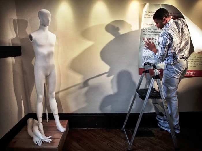 In this April 19, 2016 photo, St. George's student Noah Pope helps install an exhibit on the WWII era in Tennessee's Collierville at the city's Morton Museum. (Jim Weber/The Commercial Appeal via AP)