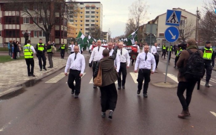 In this image made from video from Sunday, May 1, 2016, Tess Asplund gestures towards a group of far-right protesters in Borlange, Sweden. A black woman who stood up to 300 neo-Nazis in Sweden hopes her gesture will draw attention to the fight against racism in the Scandinavian country. Tess Asplund tried to block the path of the Nordic Resistance Movement as the right-wing extremist group marched in the town of Borlange on May 1. An image of Asplund facing the neo-Nazis up close with a clenched fist has been shared thousands of times on social media in Sweden and internationally. (DT.se via AP)