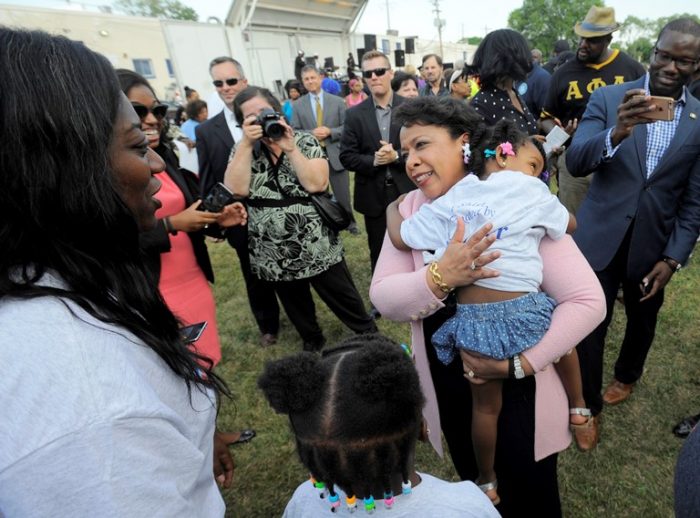 Attorney General Loretta Lynch holds Madison Wilson, 3, of Detroit, as she speaks with residents, Tuesday Aug. 2, 2016, during a National Night Out event at Fitzpatrick Play Field in Detroit. (Steve Perez/Detroit News via AP)