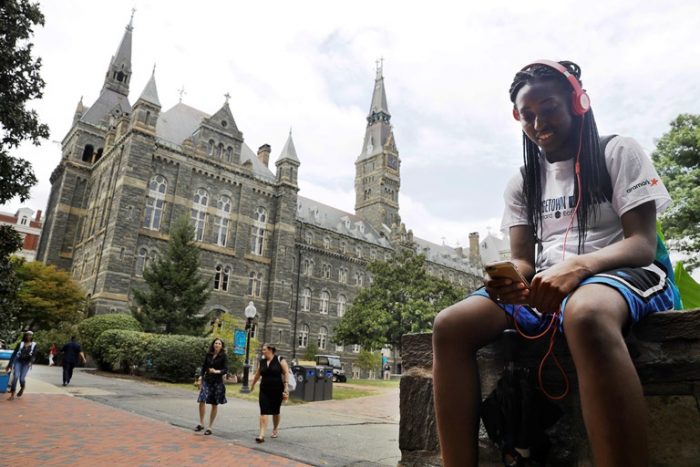 Deja Lindsey, 20, a junior at Georgetown University, talks on her cell phone in front of Healy Hall on campus, Thursday, Sept. 1, 2016, in Washington. (AP Photo/Jacquelyn Martin)