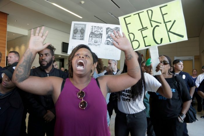 Protesters demand the firing of Los Angeles Police Chief Charlie Beck over a police-involved shooting of a black man over the weekend during a news conference at LAPD headquarters on Monday, Oct. 3, 2016. (AP Photo/Nick Ut)