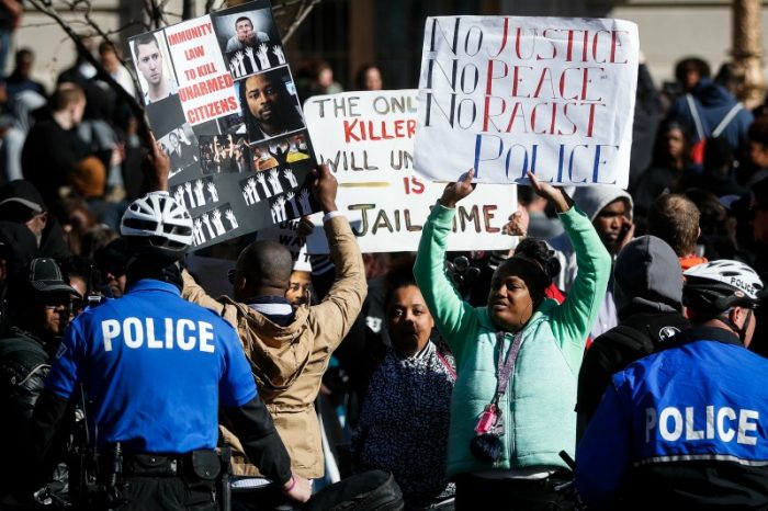 Protestors gather at a police line outside the Hamilton County Courthouse after a mistrial is declared due to a hung jury in the murder trial against Ray Tensing, Saturday, Nov. 12, 2016, in Cincinnati. (AP Photo/John Minchillo)