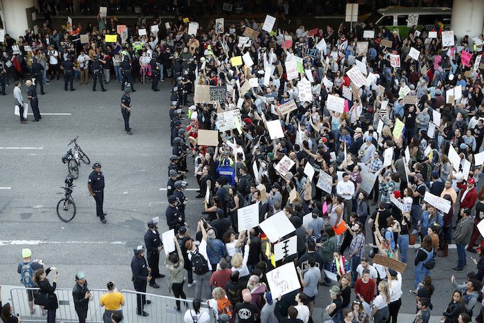 Police officers block demonstrators from marching on the lower roadway as protests against President Donald Trump’s executive order banning travel from seven Muslim-majority countries continue at Los Angeles International Airport Sunday, Jan. 29, 2017. (AP Photo/Ryan Kang)