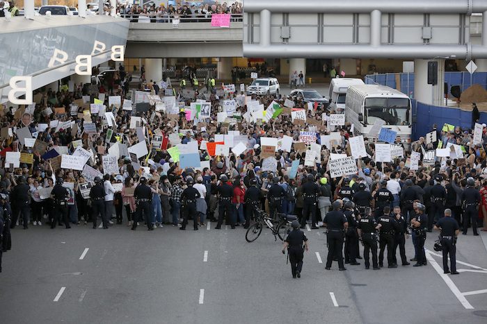 Police officers block demonstrators from marching on the lower roadway as protests against President Donald Trump’s executive order banning travel from seven Muslim-majority countries continue at Los Angeles International Airport Sunday, Jan. 29, 2017. (AP Photo/Ryan Kang)