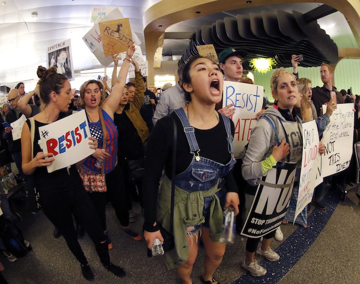 Demonstrators chant inside Tom Bradley International Terminal as protests against President Donald Trump’s executive order banning travel from seven Muslim-majority countries continue at Los Angeles International Airport Sunday, Jan. 29, 2017. (AP Photo/Ryan Kang)